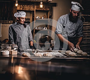 Chef teaching his assistant to bake the bread in a bakery.