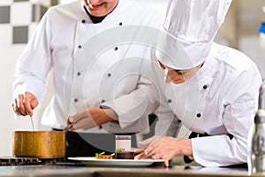 Chef team in restaurant kitchen with dessert