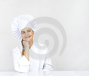 Chef thinking looking smiling and happy to the side. Woman chef, cook or baker in chef uniform and hat.