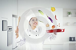 Chef throws food ingredients in a frying pan