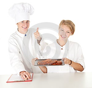 Chef with thumb up examining cook,