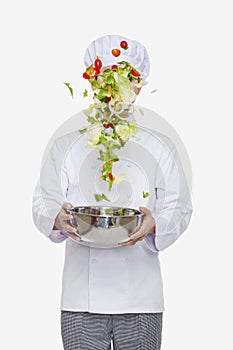 Chef tossing a salad, studio shot