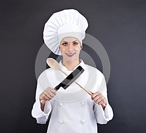 Chef in uniform holding a kitchen knife and spoon