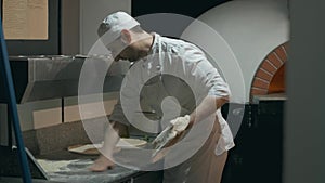 The chef in uniform prepares the pizza dough then professionally throws up. 4K footage