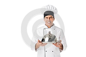 Chef in uniform and toque blanche holding tray with cover