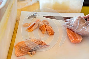 Chef use knife preparing a fresh salmon on a cutting board, Japanese chef in restaurant slicing raw salmon, ingredient for seafood