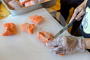 Chef use knife preparing a fresh salmon on a cutting board, Japanese chef in restaurant slicing raw salmon, ingredient for seafood