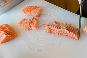 Chef use knife preparing a fresh salmon on a cutting board, Japanese chef in restaurant slicing raw salmon, ingredient for seafood