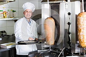 Chef wearing uniform cooking pizza in pan