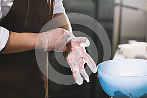 The chef wears gloves to mix the salad