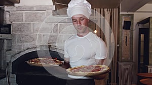 Chef in white uniform making pizza in Italian restaurant
