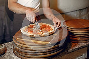 Chef in a white uniform prepare a pizzaa