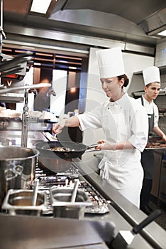 Chef, woman and frying pan with sauce in kitchen, catering service and prepare food for restaurant fine dining