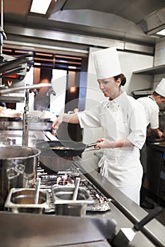 Chef, woman and frying pan with sauce in restaurant kitchen, catering service and prepare food for fine dining