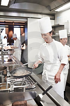 Chef, woman and frying in restaurant kitchen, catering service and prepare food for fine dining. Professional, cooking