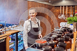 Chef woman prepare traditional pasta sauce on restaurant kitchen stove