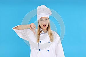 Chef woman showing thumb down on blue background