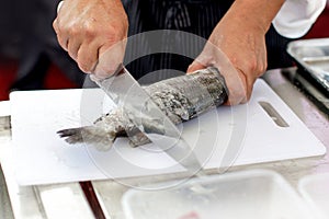 Chef at work,  chef filleting fish at the kitchen, Chef in restaurant kitchen filleting fish