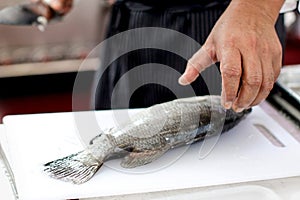 Chef at work,  chef filleting fish at the kitchen, Chef in restaurant kitchen filleting fish