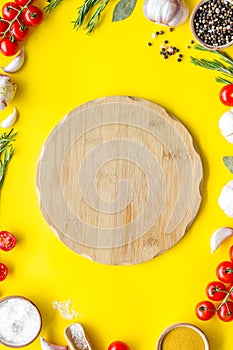 Chef work space with products and cutting board on yellow background top view mock up