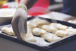 Chef working with dough in bakery. Cooking fancy bread, making delicious pastry