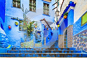 Chefchaouen, Morocco. Blue staircase and wall decorated with colourful flowerpots