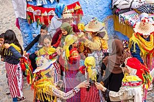 Chefchaouen, Morocco - November 4, 2019: A group of women try on shawls and hats in a store