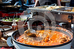 Cheff cooking delicious chicken soup dish outdoor.