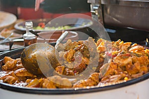 Cheff cooking delicious meat dish in a large pot.