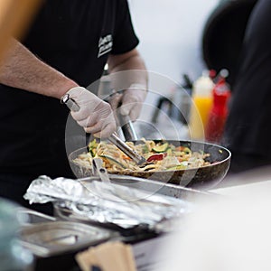 Cheff cooking on outdoor street food festival.