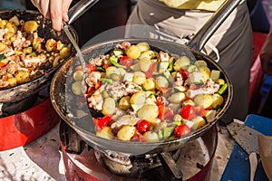 Cheff cooking traditional Mediterranean octopus on street stall.