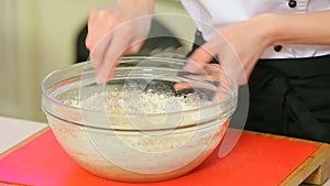 Cheff is making dough in a glass bowl