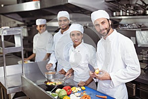 Chefs chopping vegetables on chopping board in the commercial kitchen photo