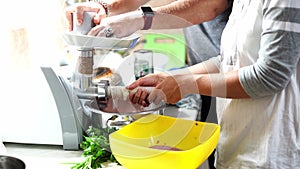 Chefs fill intestines with minced meat in a meat grinder