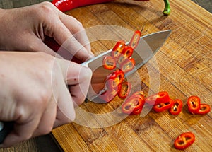 Chefs hands chopping chili pepper