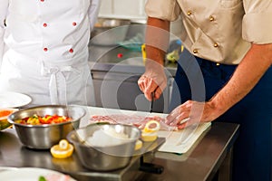 Chefs preparing fish in restaurant or hotel kitchen