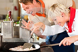 Chefs in a restaurant or hotel kitchen cooking