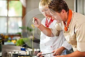 Chefs in a restaurant or hotel kitchen cooking