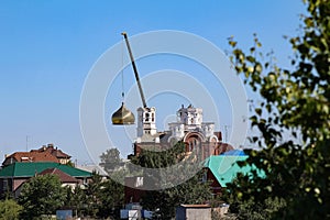 Chelyabinsk, Russia-08.06.2021: A crane that lifts the golden dome of the church during construction