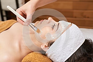 Chemic facial peel mask. Cosmetology acne treatment. Young girl at medical spa