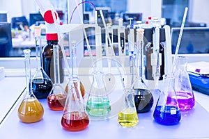 Chemical analysis, pharmacology and laboratory concept. Flasks with colored liquid reagents in a science laboratory. Blue toned