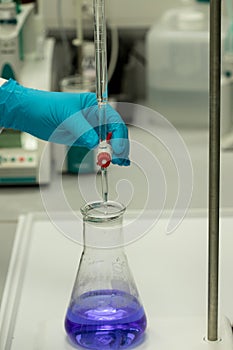 Chemical analysis by titration of blue solution.