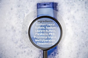 Chemical components on the shampoo label:  Sodium Lauryl Sulfate sls, sles. A hand holds a blue jar and a magnifier, where the