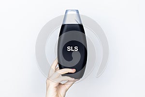 Chemical components on the shampoo label:  Sodium Lauryl Sulfate sls, sles. A hand holds a jar and a magnifier, where the