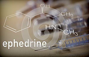 Chemical composition of ephedrine next to syringe