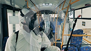 Chemical disinfection of a bus done by a group of experts. Covid-19, coronavirus pandemic, disinfection concept.