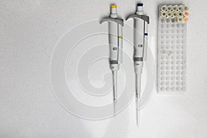 Chemical equipment are on the white background. Automatic pipettes and microtube rack on the working surface in the scientific.