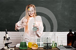 Chemical experiment. Funny schoolgirl kid doing experiments in the laboratory. Explosion in the lab. Science and