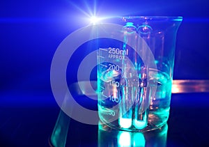 Chemical experiment glass beaker. Glass flask filled with transparent liquid.