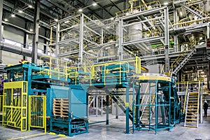 Chemical factory. Thermoplastic production line and packing machinery in large area of industrial hall